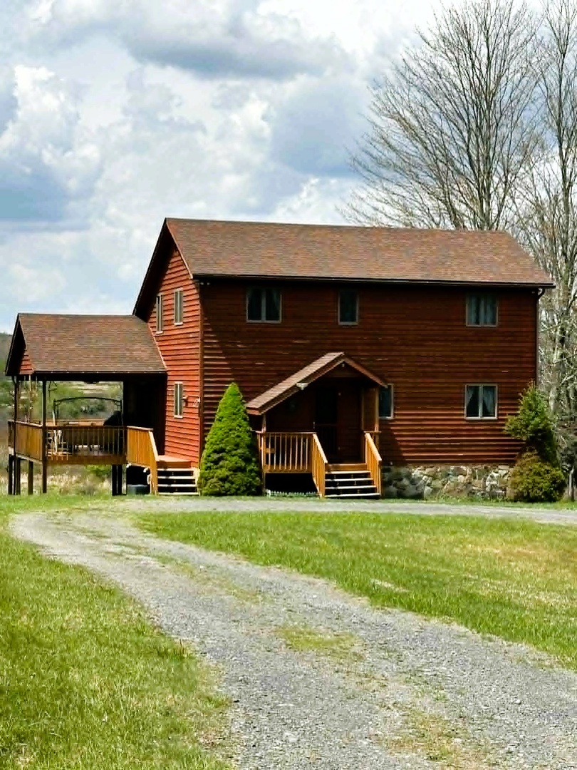 Rustic wooden cabin retreat featuring natural cedar siding and elevated decking, surrounded by peaceful countryside setting.
