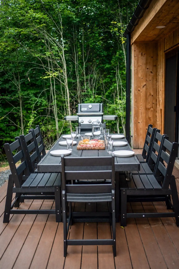 Gather your group around this welcoming outdoor table, perfectly set for alfresco dining with a grill ready and lush forest views surrounding your private deck retreat.