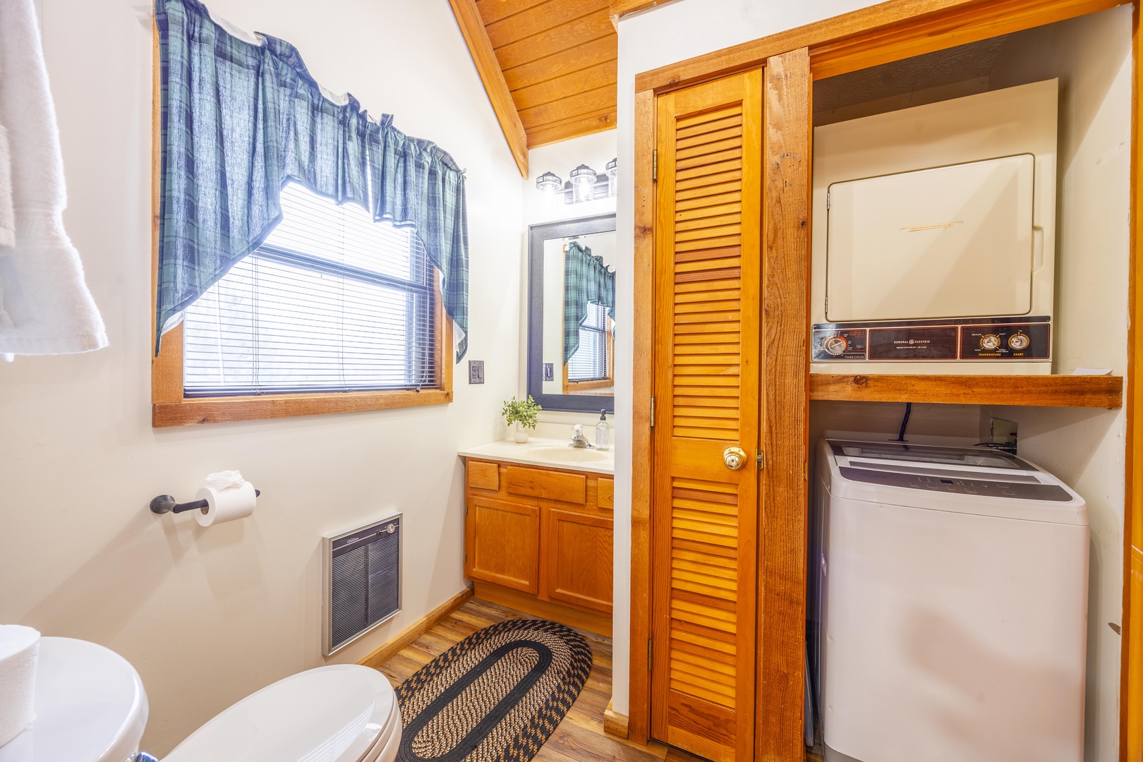 Your bright, cozy bathroom features warm wood accents and in-unit laundry for ultimate convenience during your stay.