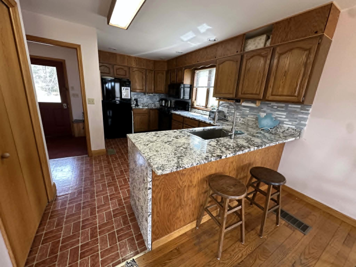 Cook your favorite meals in this spacious kitchen featuring granite counters, full appliances, and a breakfast bar for morning coffee.