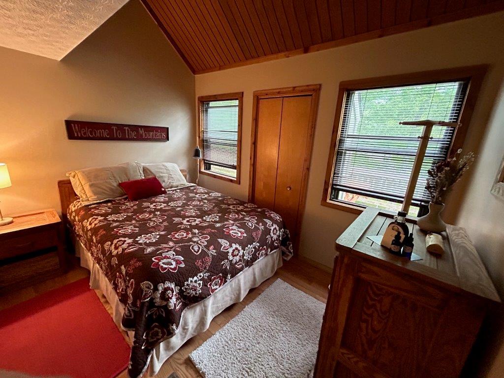 Unwind in your cozy mountain retreat with warm wood accents, comfortable bedding, and peaceful forest views from your windows.