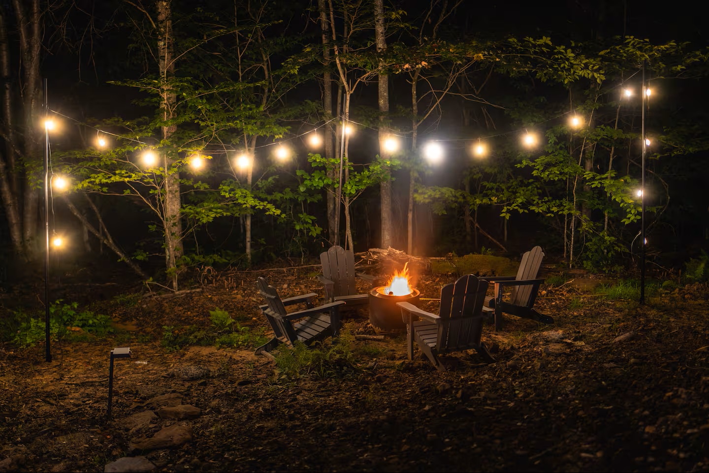 Picture yourself gathered around the crackling fire under a canopy of twinkling lights, relaxing into your evening surrounded by peaceful woods. This cozy outdoor retreat invites you to unwind and reconnect.