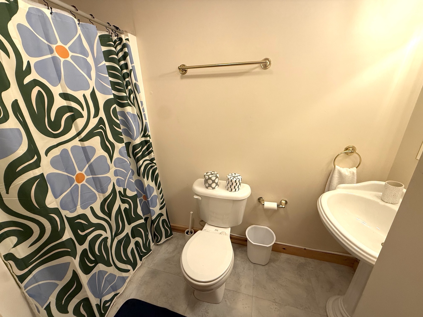 Your private bathroom features a refreshing shower, modern fixtures, and cheerful floral accents.