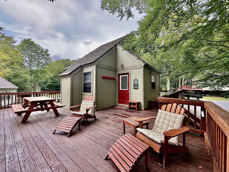 Your private woodland cabin features a spacious deck with comfy lounge chairs and picnic table, perfect for morning coffee surrounded by nature.