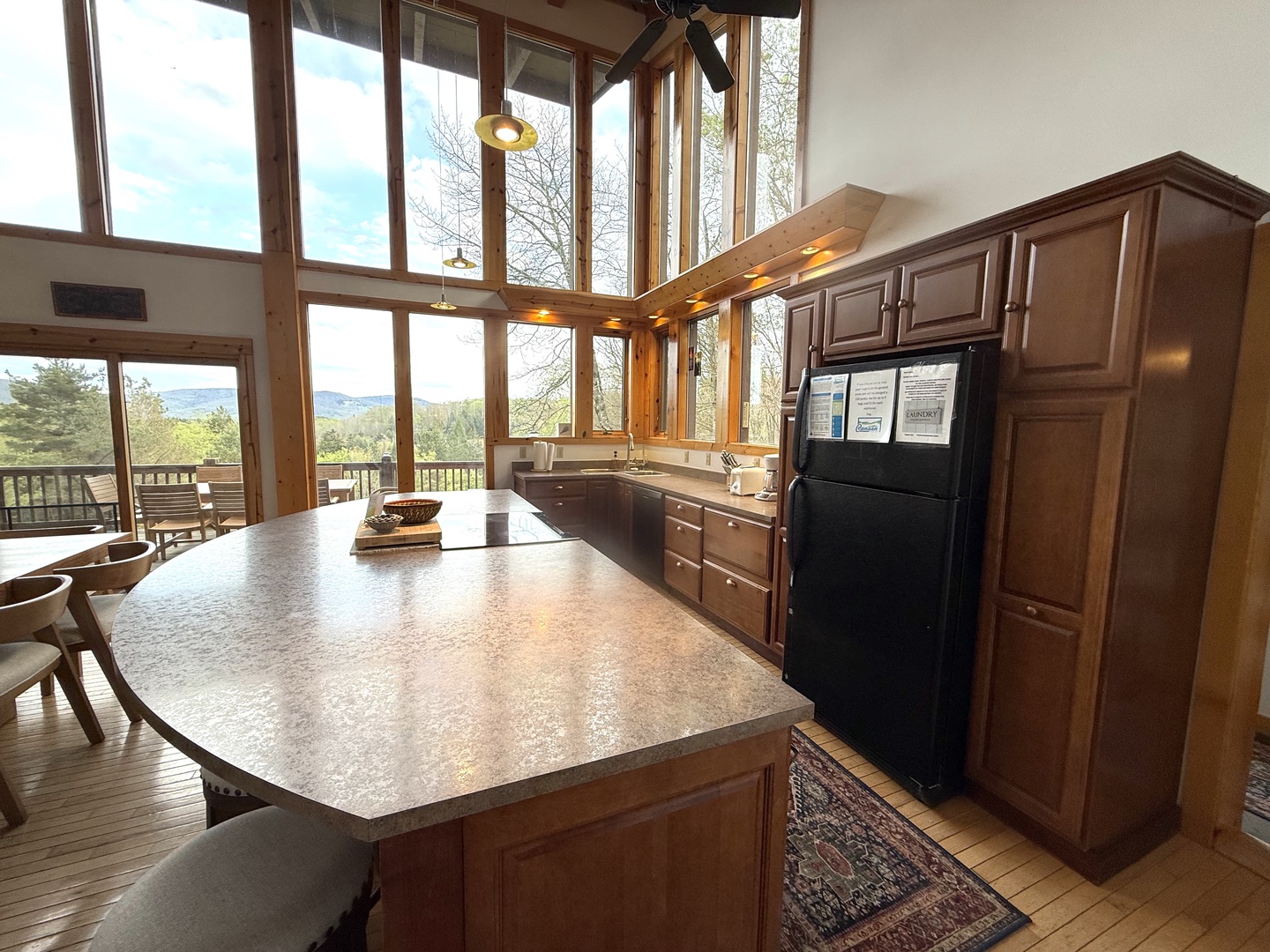 Prepare your favorite meals in this sun-filled kitchen featuring sleek countertops and modern appliances, all while soaking in stunning mountain views through floor-to-ceiling windows that frame nature's beauty.