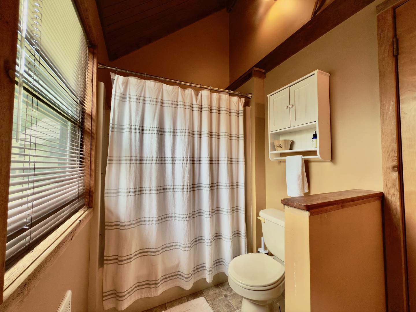Step into your rustic bathroom featuring exposed beams, natural light, and thoughtful touches that make your stay comfortable.