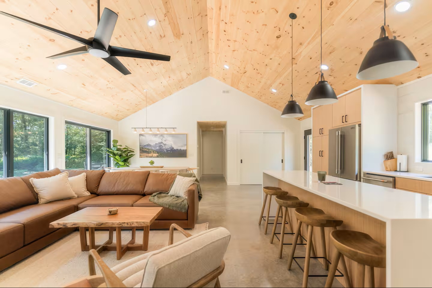 Open-concept retreat with soaring wood ceilings and modern design. Spacious living area and generous kitchen island create the perfect gathering space for your mountain getaway.