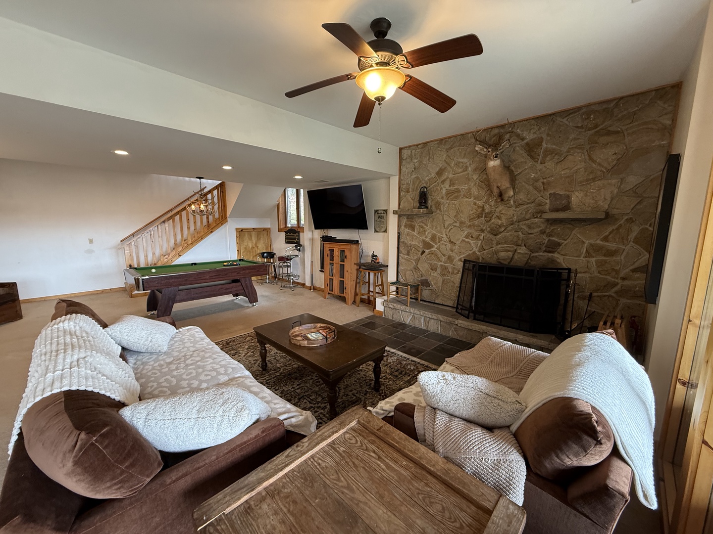 Sink into cozy seating by your stone fireplace while enjoying pool table games in this spacious living area.