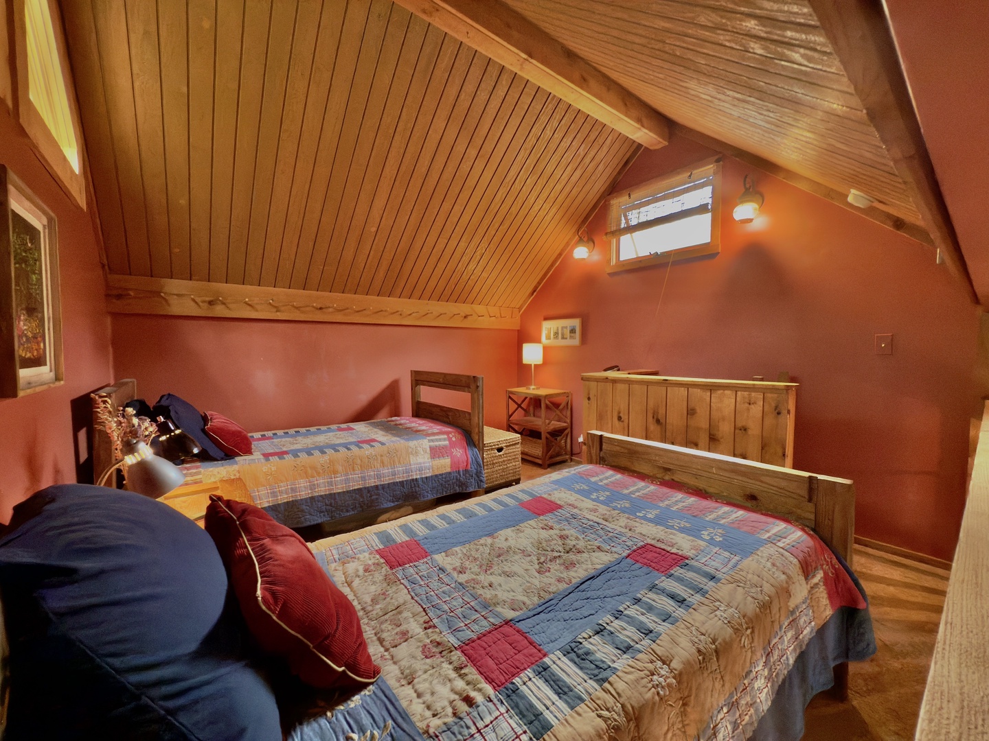 Cozy twin bedroom with rustic charm where you can unwind under vaulted wooden ceilings and colorful quilts.