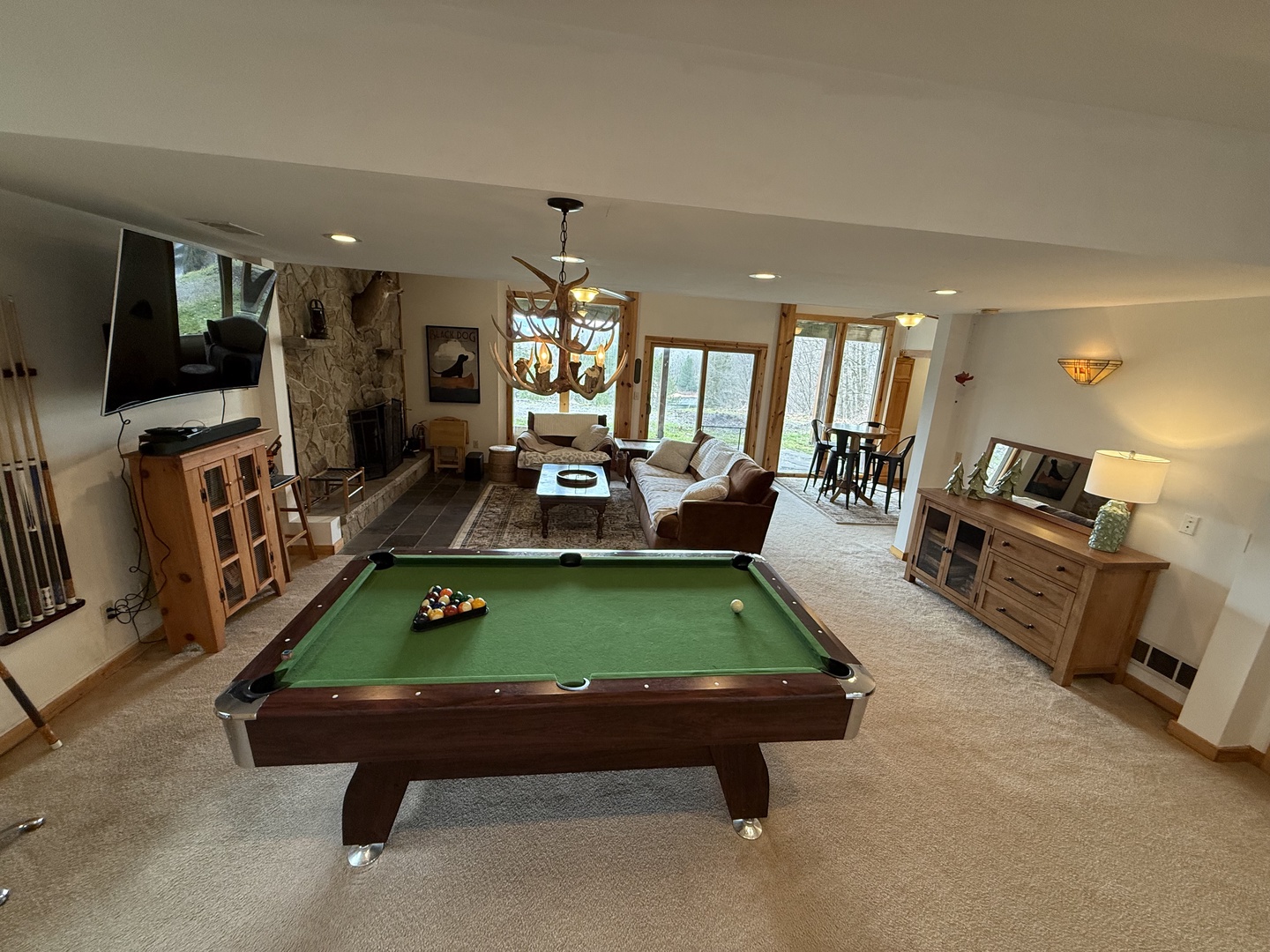 Challenge friends to pool while enjoying your spacious living area with stone fireplace, comfortable seating, and mountain views through large windows.