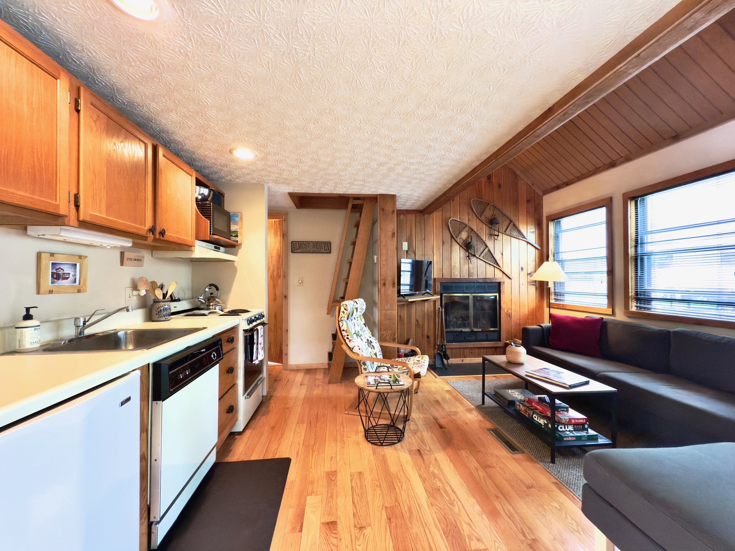 Cozy nautical-themed living space with warm wood accents, fully equipped kitchen, and comfortable seating for your perfect getaway.