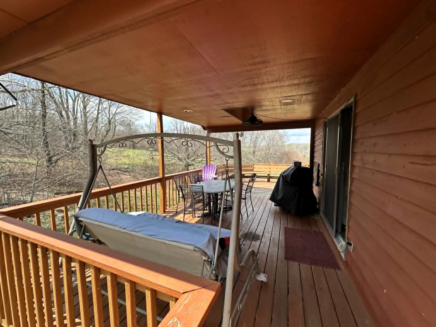 Your private deck offers peaceful moments with a charming swing, dining space, and grill overlooking natural scenery.