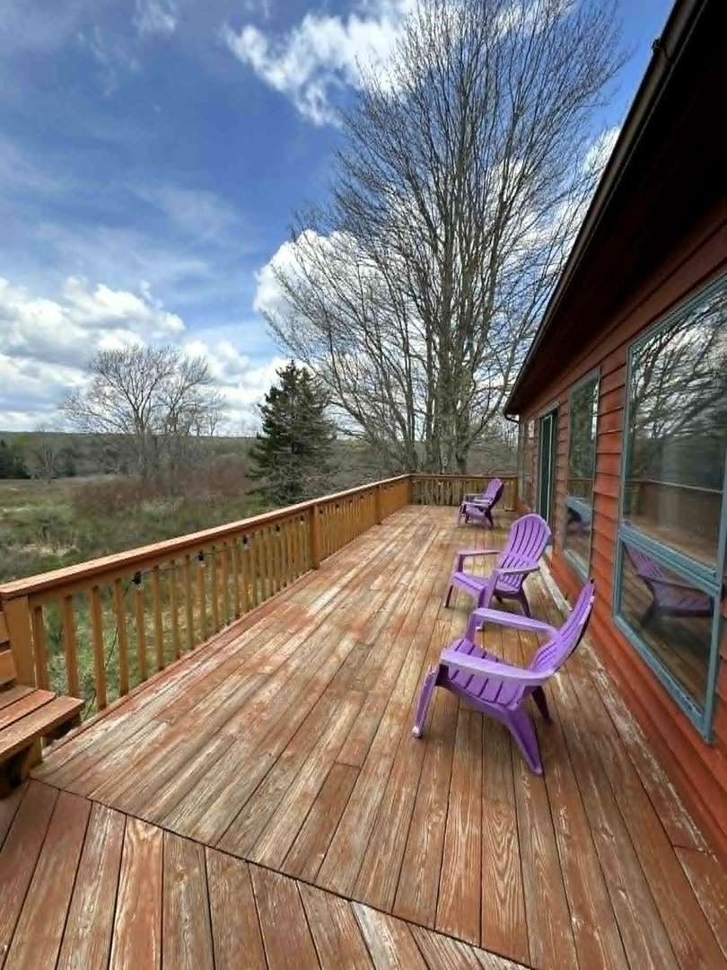 Unwind on your private deck with colorful Adirondack chairs, where peaceful countryside views create the perfect backdrop for morning coffee or sunset relaxation.