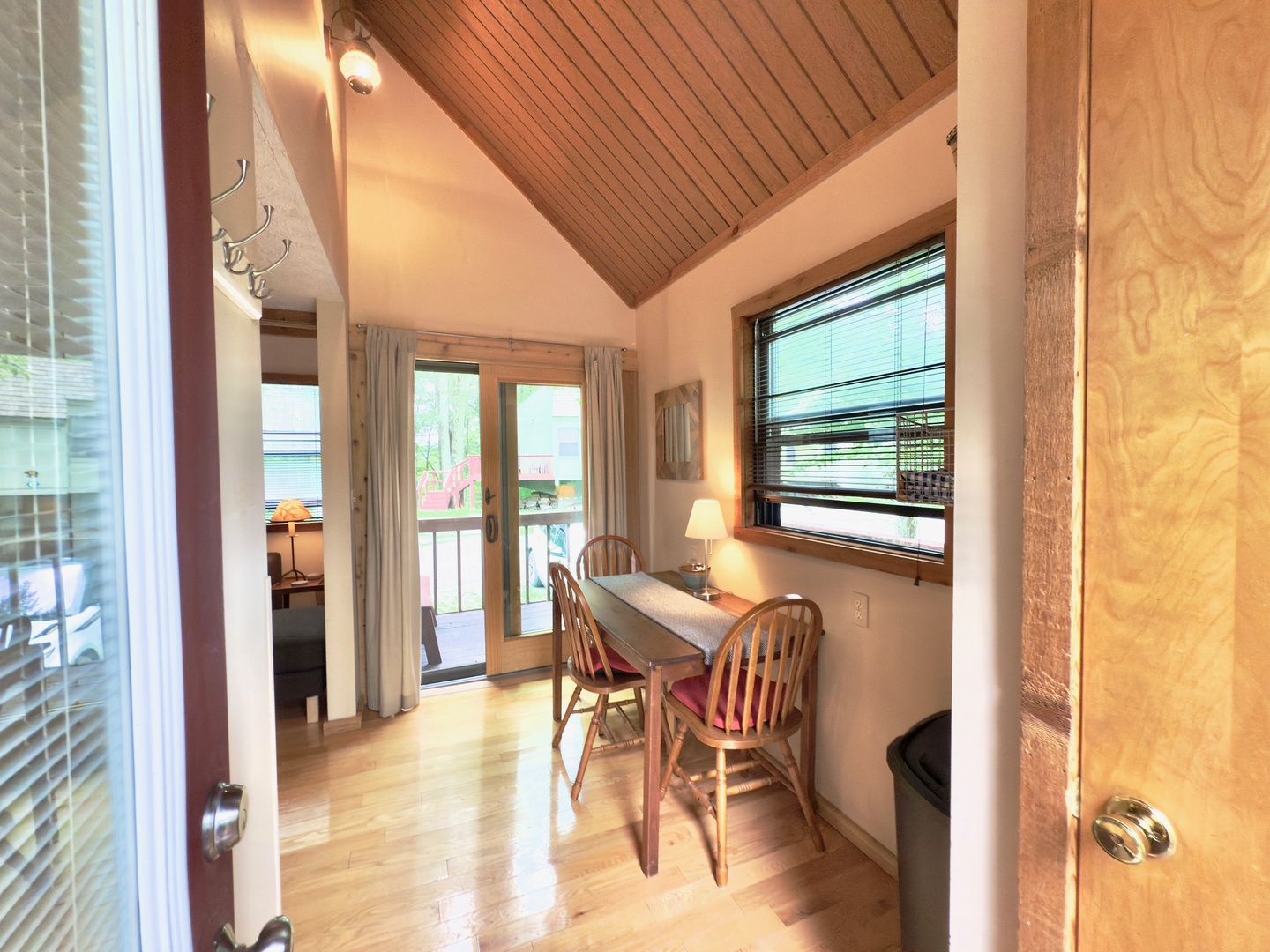 Your cozy dining nook features warm wood tones and cathedral ceilings, perfect for morning coffee or intimate meals with balcony access.