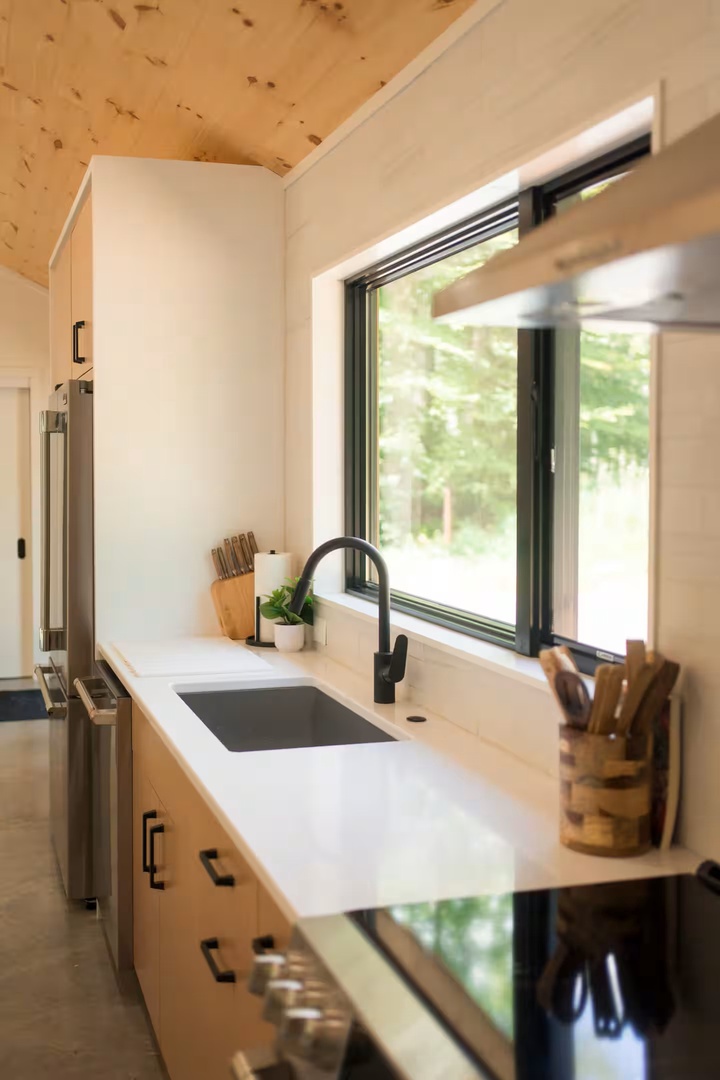Your fully equipped kitchen offers clean countertops, modern appliances, and a large window framing the natural beauty outside. Whether brewing morning coffee or preparing a home-cooked meal, you'll feel right at home in this inviting space.