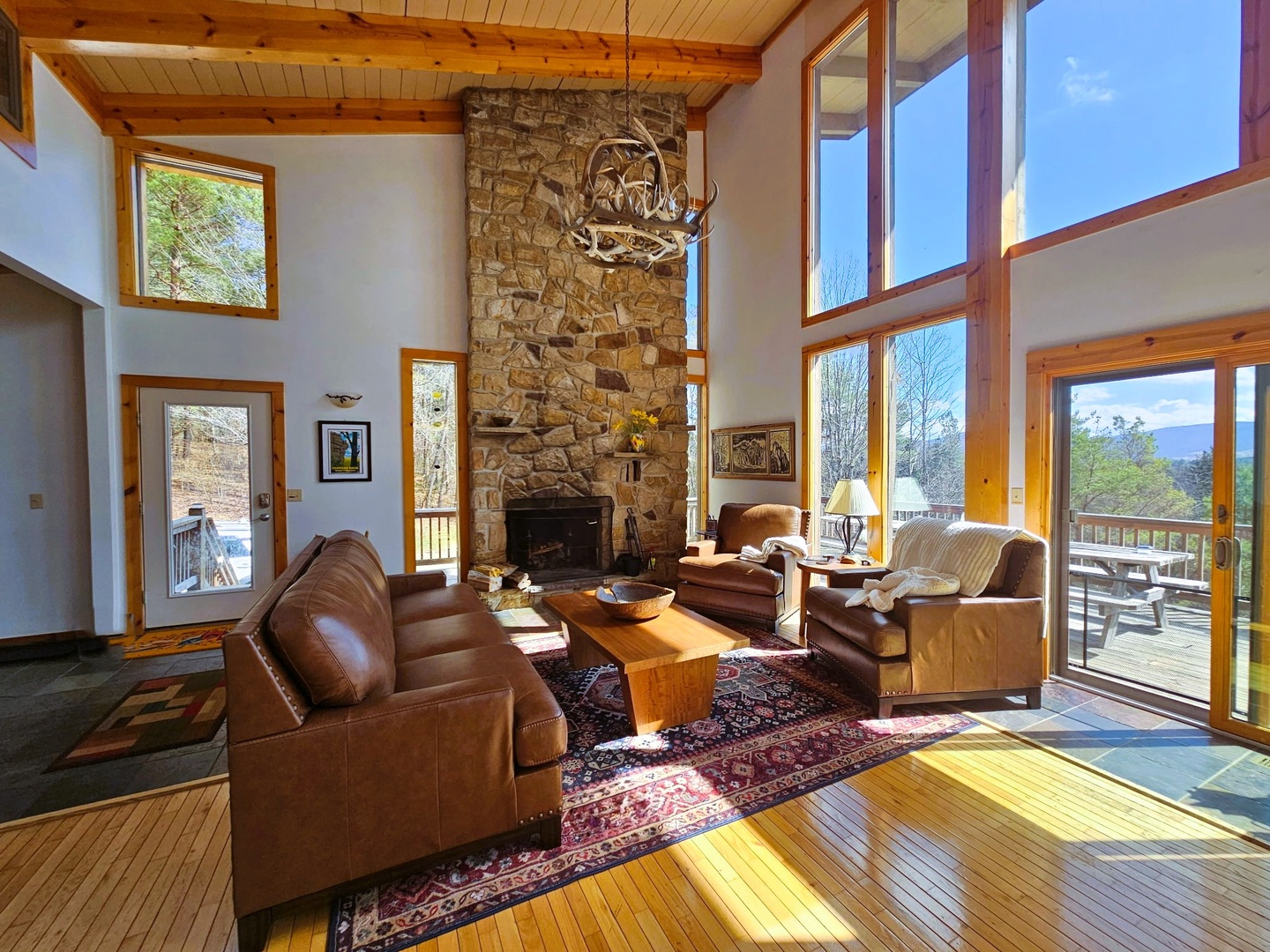 Sink into plush leather seating by the stone fireplace while sunlight streams through soaring windows, framing stunning mountain vistas.