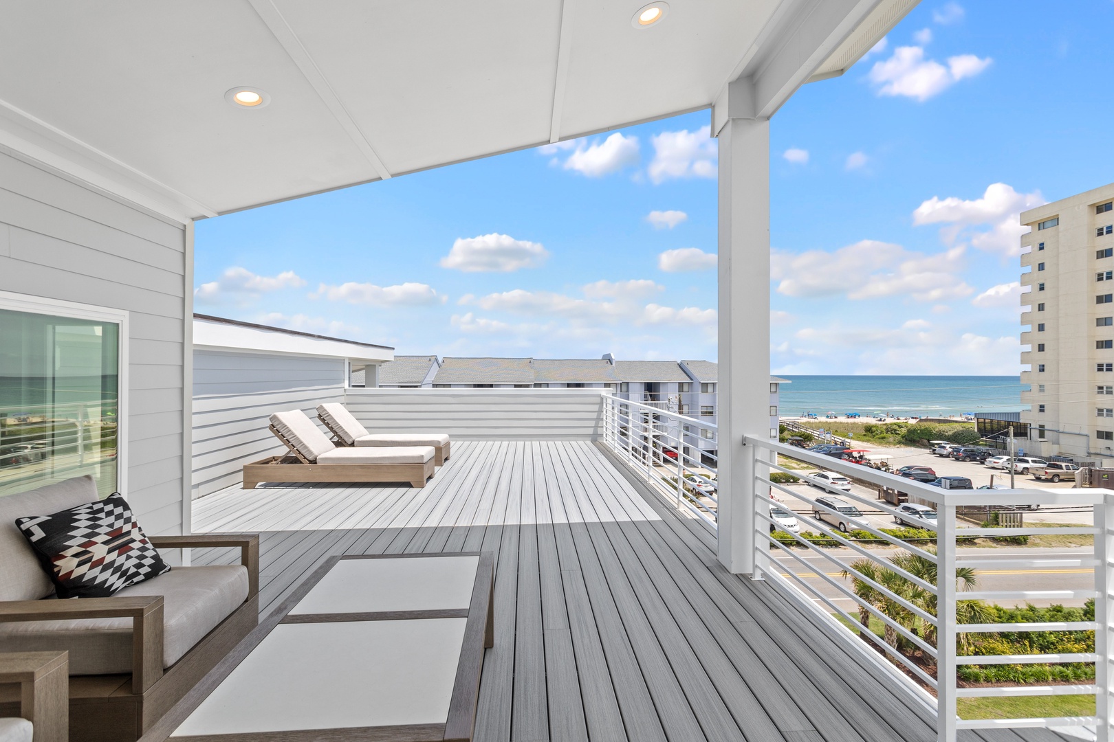 The top-floor partially covered deck with expansive ocean views
