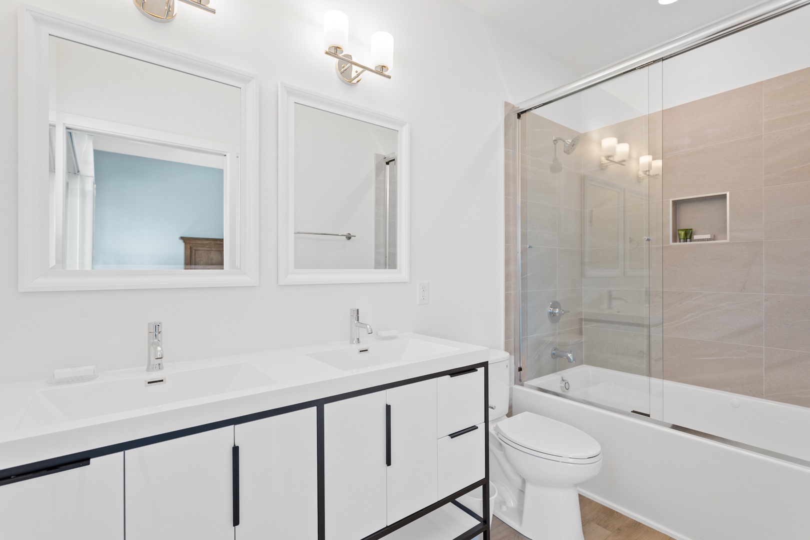 The primary ensuite bathroom with a double vanity and shower-tub combination