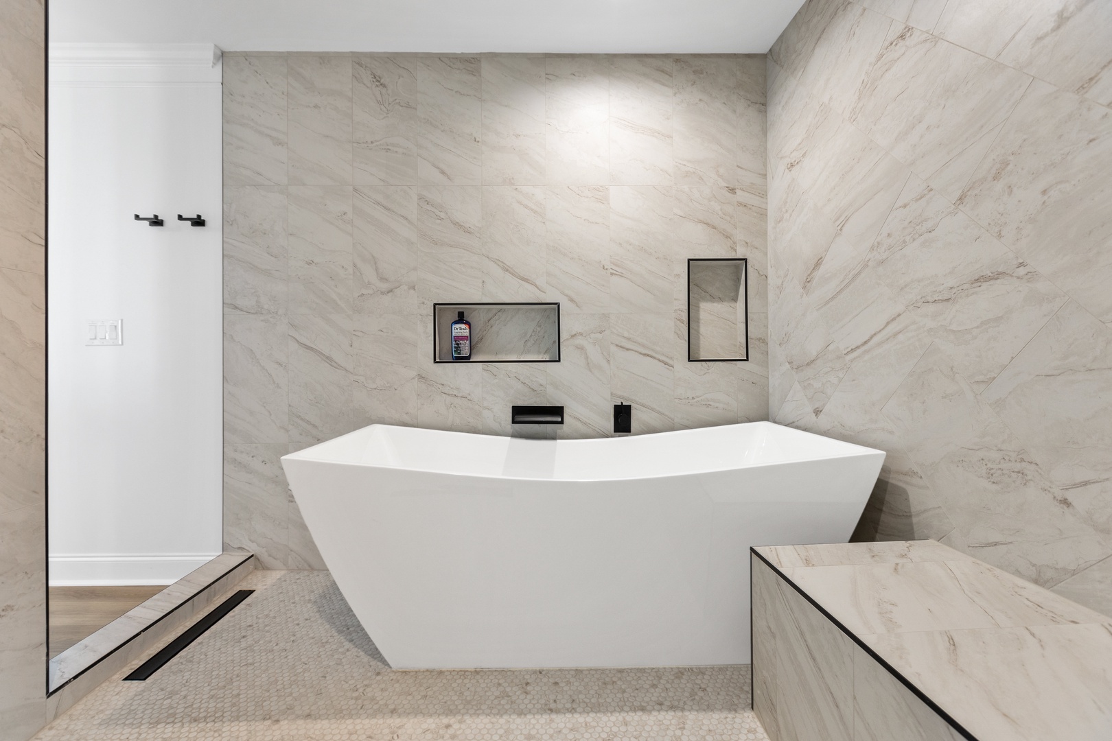 The primary ensuite with a a dual vanity, walk-in shower, and tub