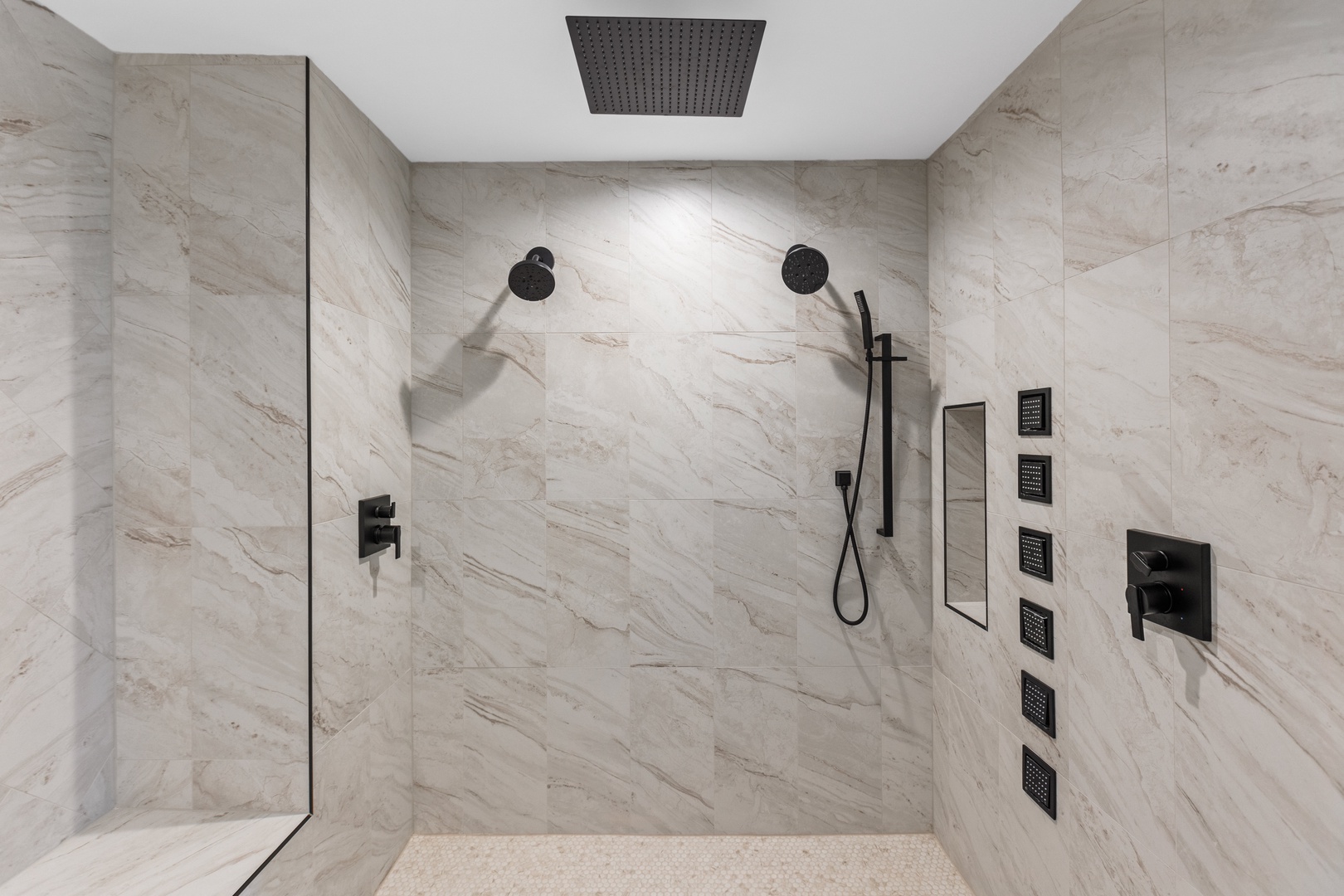 The primary ensuite with a a dual vanity, walk-in shower, and tub