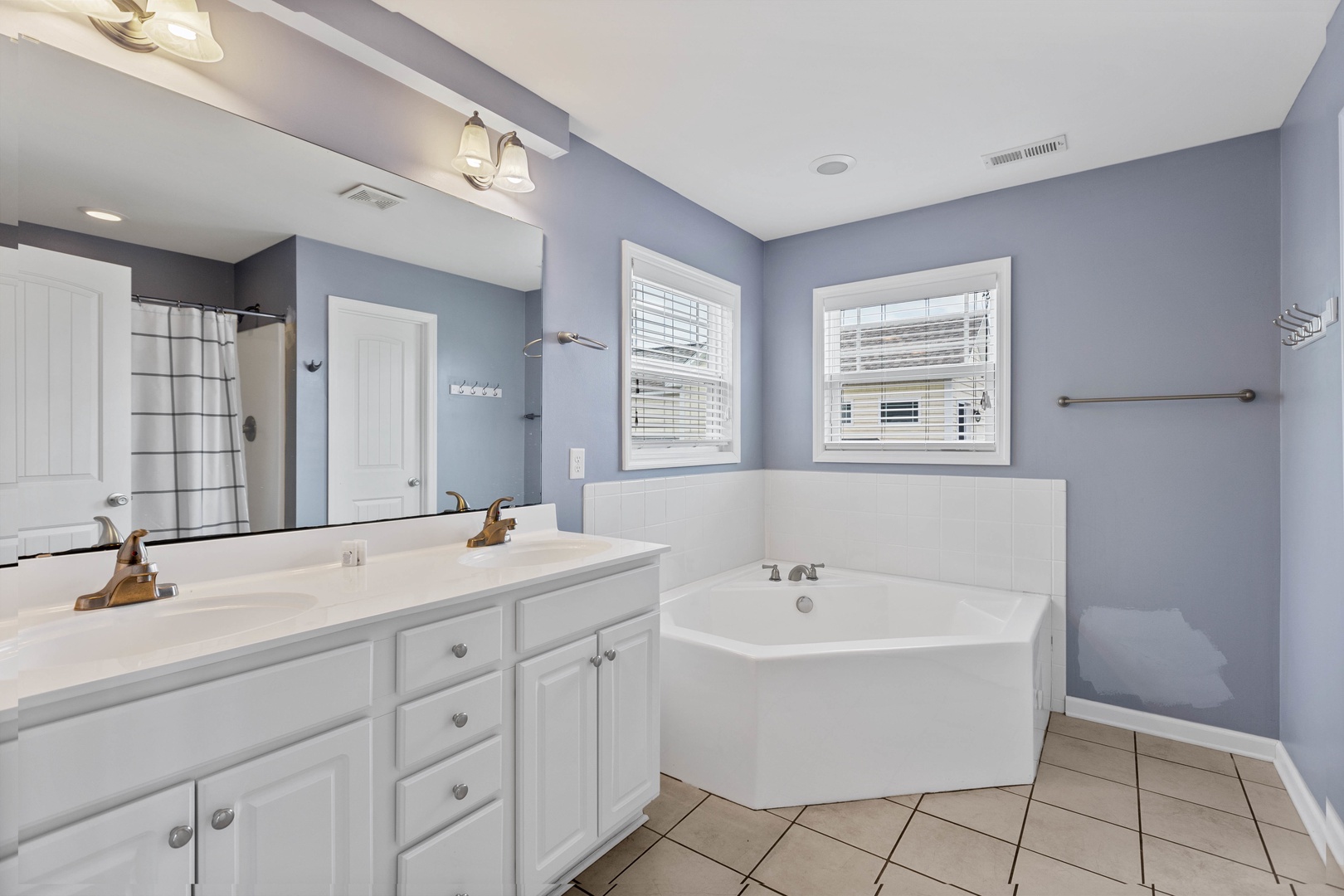 The ensuite bathroom with a walk-in shower, separate tub, and double vanity