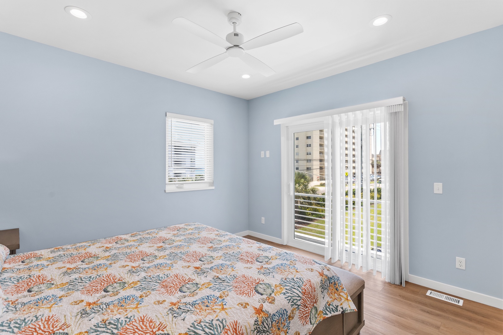 The primary bedroom with a king-sized bed and direct balcony access