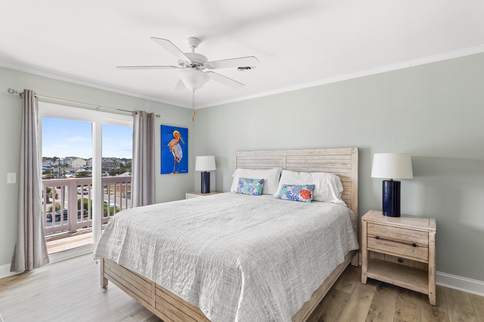 The primary bedroom with a king-sized bed, Smart TV, and balcony access