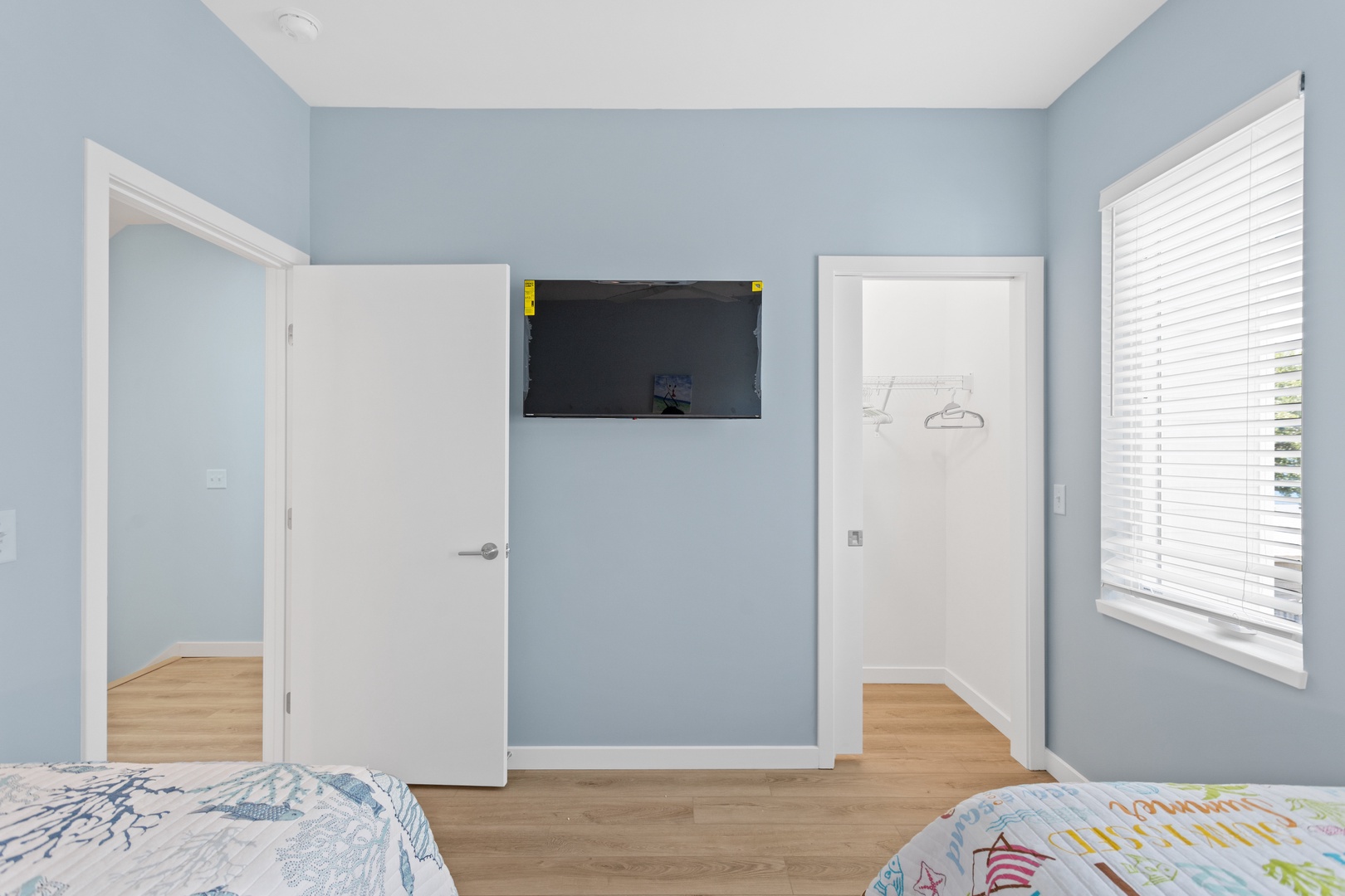 The guest bedroom with two twin-sized beds and a Smart TV