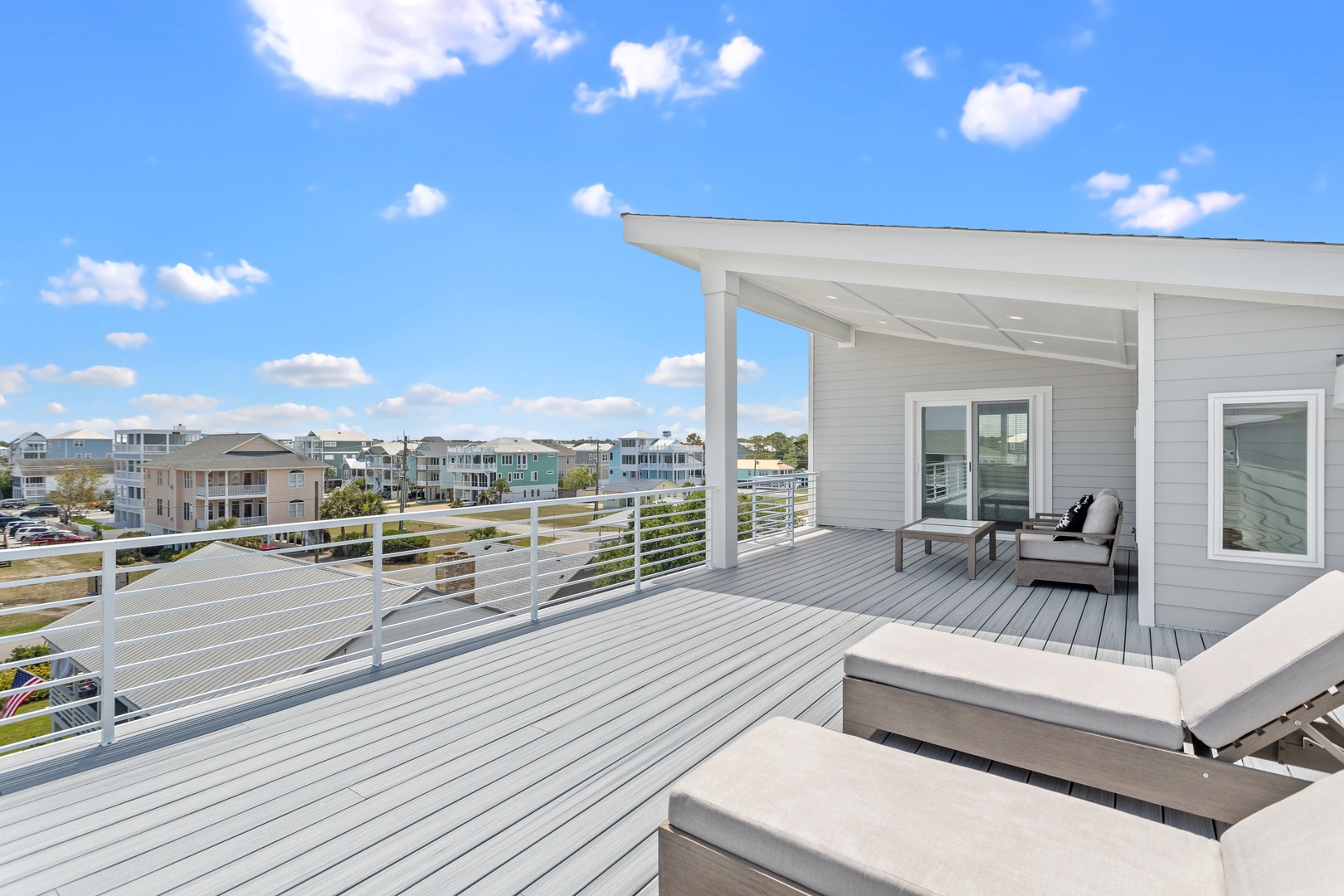 The top-floor partially covered deck with expansive ocean views