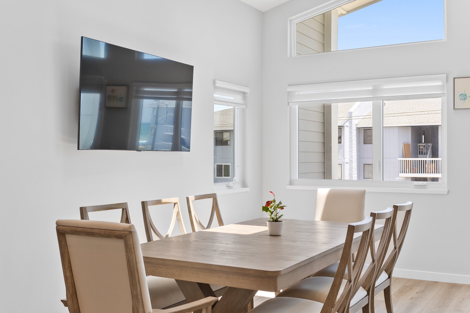 The open living, kitchen, and dining areas with a Smart TV and balcony access