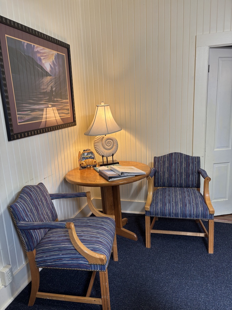 Settle into this charming dining nook where coastal-blue striped chairs invite you to linger over morning coffee or evening meals. The warm wood table and nautical touches create an intimate space just for you.