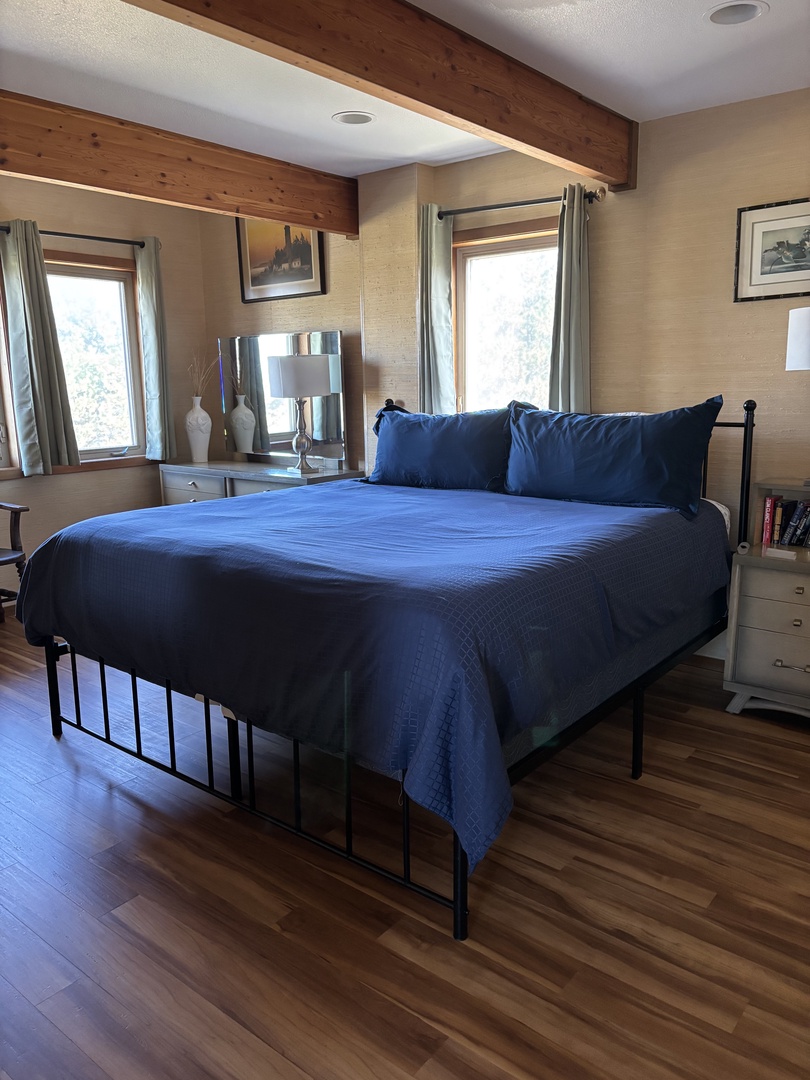 Slide into crisp blue linens and let the natural light gently wake you. Your cozy retreat features warm wood tones and a peaceful ambiance—perfect for unwinding after a day of adventure.