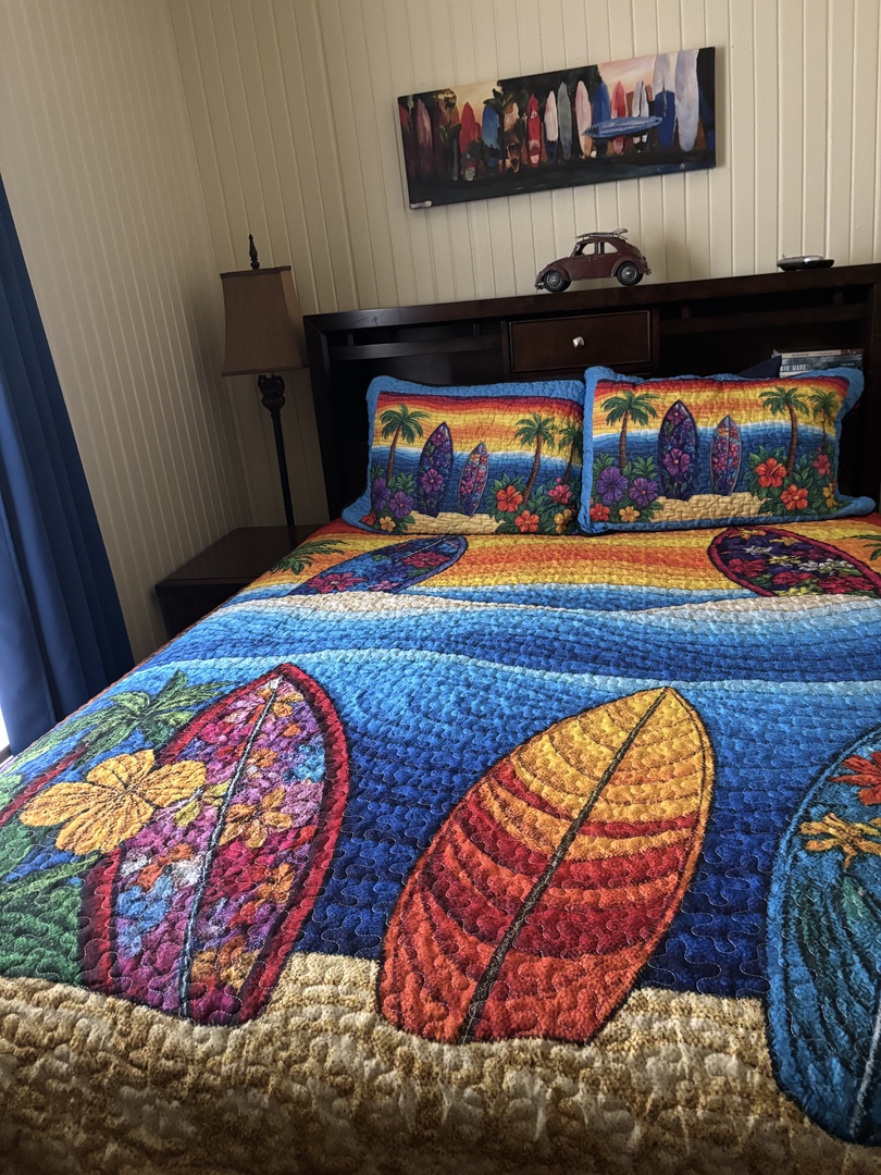 Sink into this cozy bed dressed in vibrant tropical quilts that invite you to dream of island getaways. Warm wood tones and soft textures create your perfect beachside retreat.
