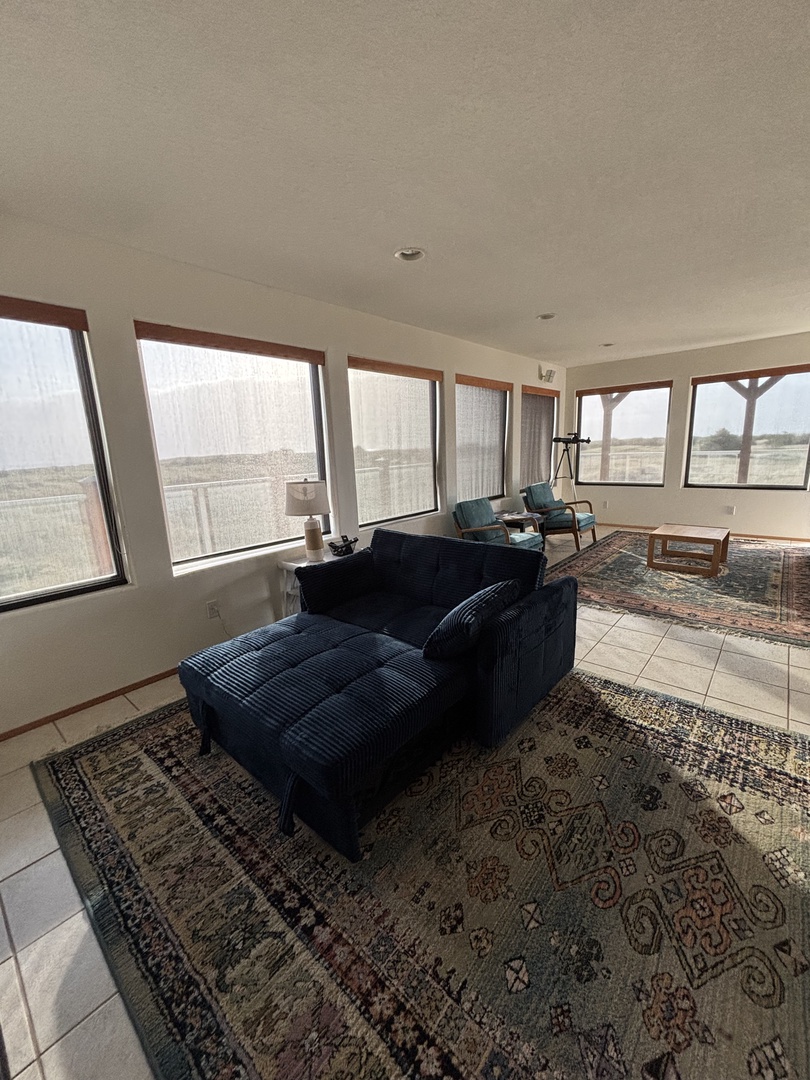 Relax on your plush navy sofa while city views unfold through expansive windows, creating your perfect urban retreat.