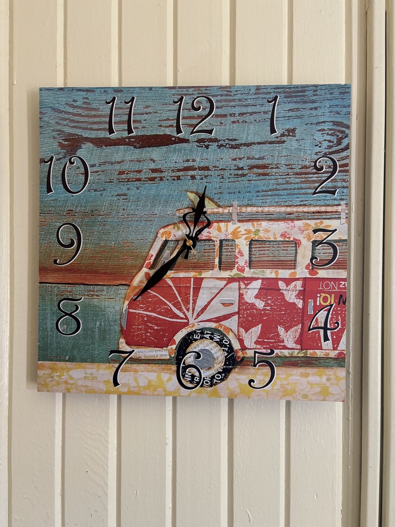 Charming vintage-style clock adds a pop of coastal color and character to your space, blending rustic weathered wood tones with playful seaside motifs.
