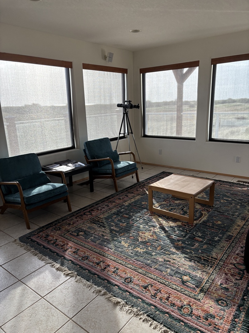 Settle into your comfortable dining space with elegant chairs and beautiful rug, where natural light streams through large windows.