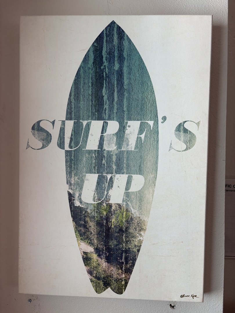 A decorative surfboard art piece featuring coastal imagery creates a relaxed, beachy vibe in your space.