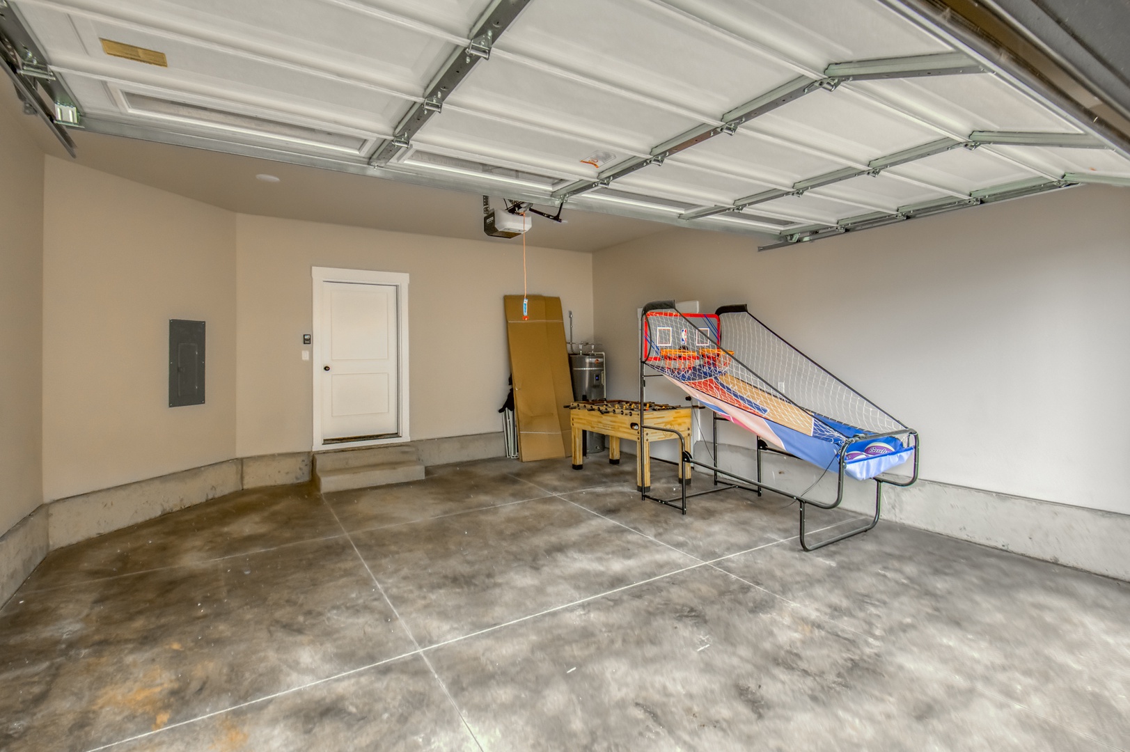 Fun for everyone with an arcade basketball and foosball in this spacious garage setting.