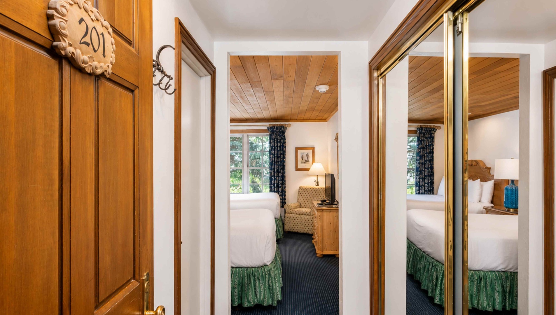 Step into your cozy retreat with warm wood tones and a plush bed ready to cradle you after a day of exploring. The peaceful room invites you to unwind in comfort and style.
