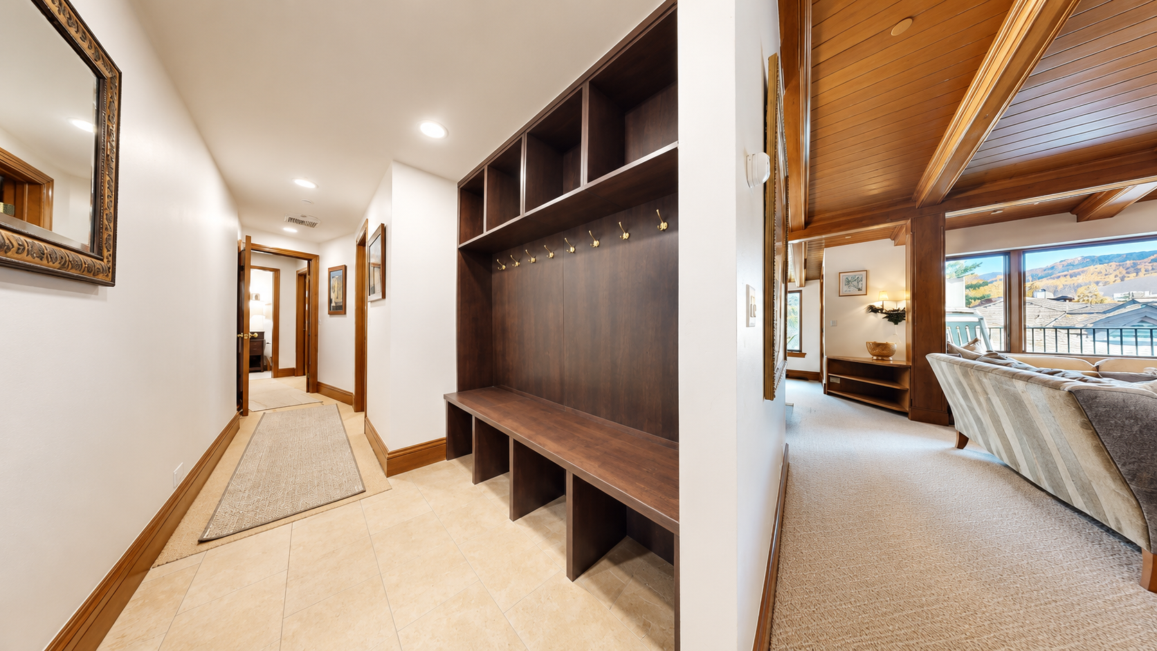 Your entryway welcomes you with built-in storage and hooks for gear, connecting seamlessly to a cozy living space where mountain views await through bright windows.