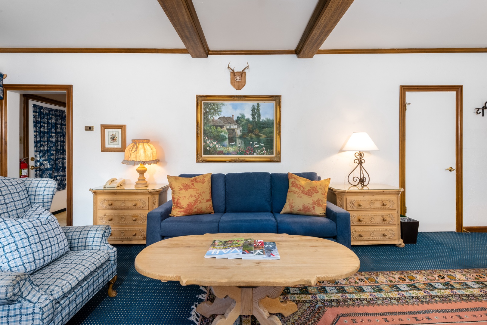 Settle into your cozy living room featuring rustic exposed beams, charming wood furnishings, and inviting sofas perfect for unwinding after a day of adventure.