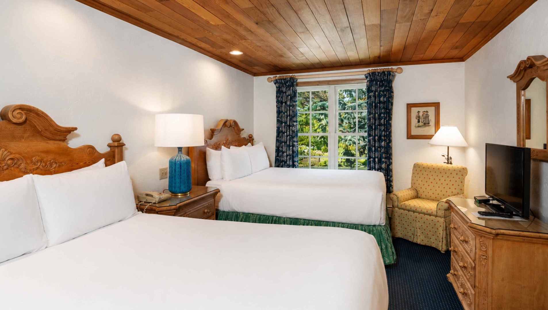 Unwind in your cozy retreat with two plush beds, charming wood accents, and a garden view that brings the outdoors in.