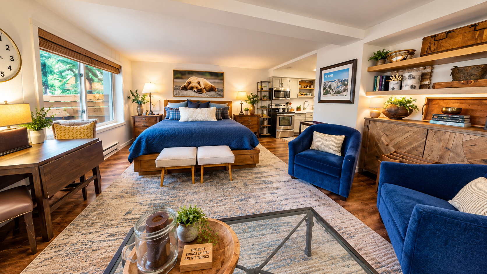 Sink into rich blue velvet chairs, unwind on your plush bed, and enjoy your open-concept retreat. Natural light, warm wood tones, and a cozy kitchen make this your perfect home base.