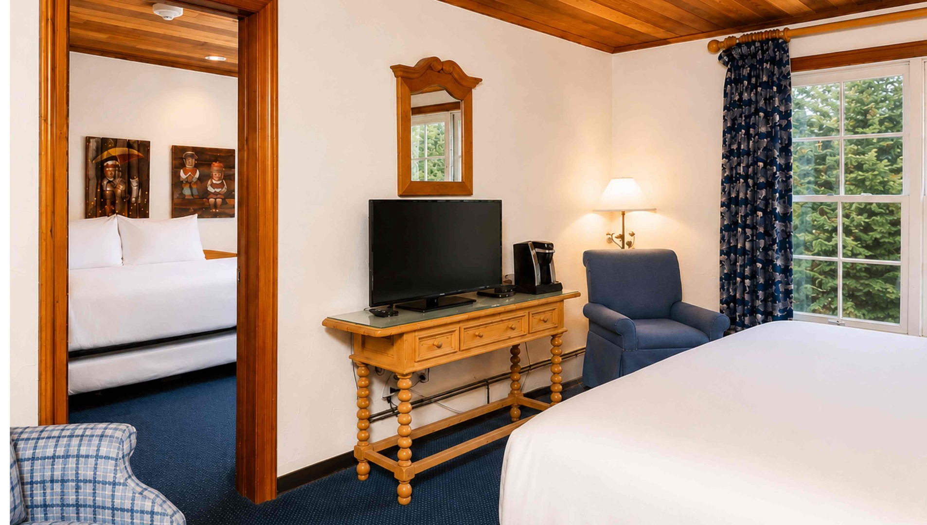 Relax in your spacious retreat with warm wood accents, charming décor, a flat-screen TV, and peaceful garden views framed by large windows.