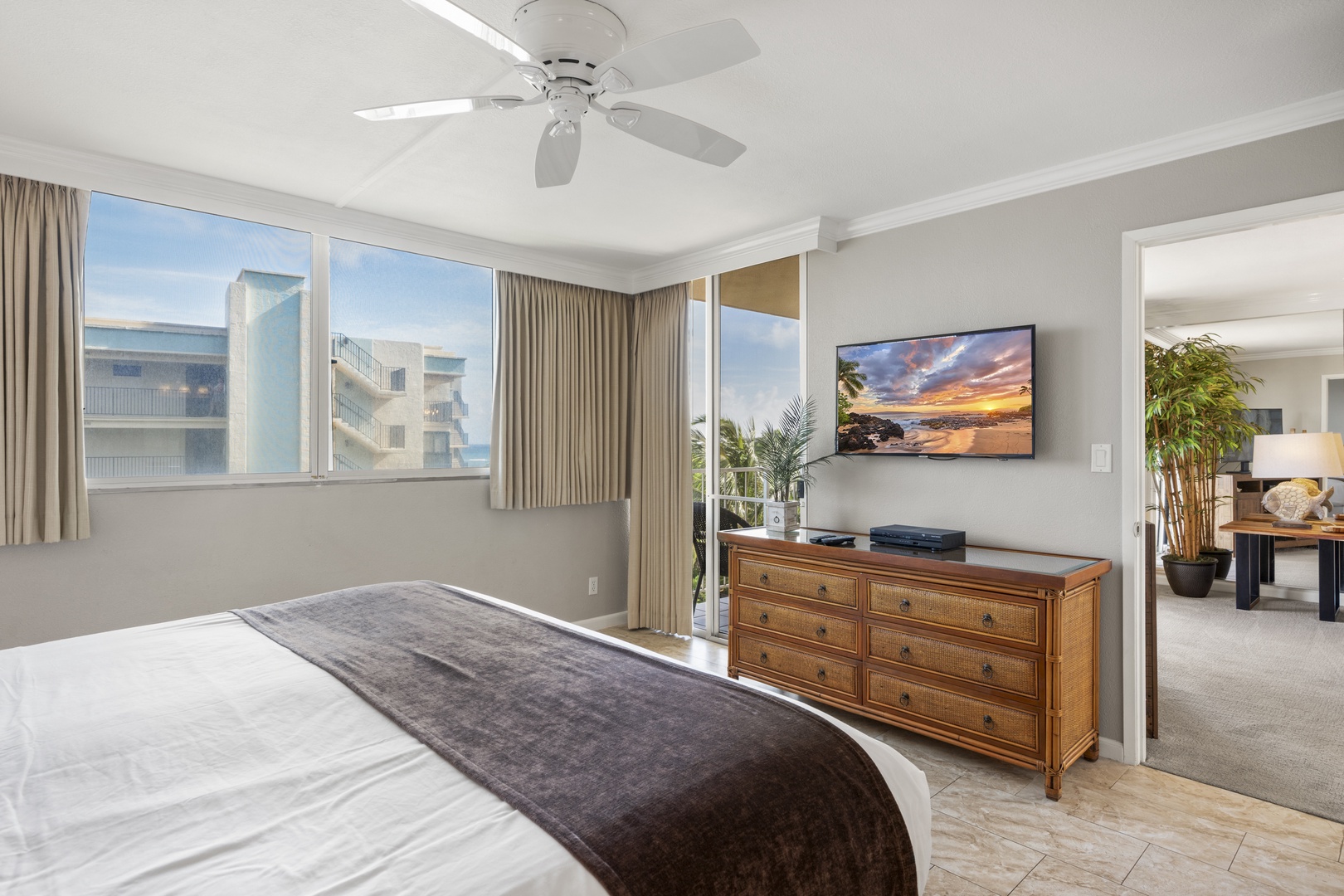 Your bright, airy retreat features coastal-inspired décor and opens to a private balcony where palm trees hint at beachside relaxation. Unwind under the ceiling fan's gentle breeze after exploring everything nearby.