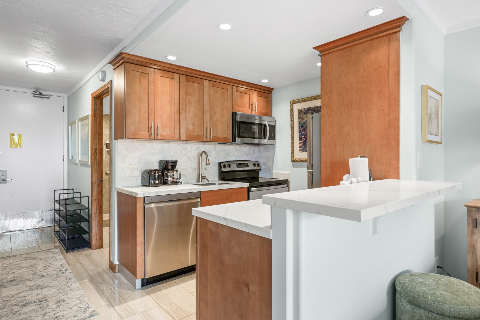 Your fully equipped kitchen features gleaming cabinetry, stainless steel appliances, and a bright breakfast bar—perfect for whipping up morning coffee or sharing meals together in style.