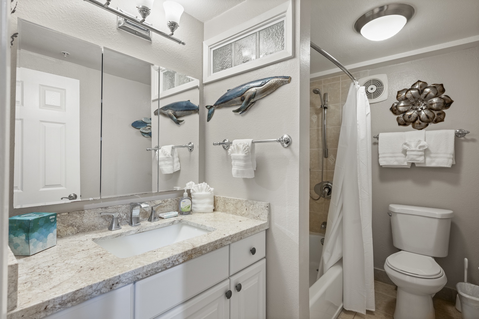 Your private bathroom features a granite-topped vanity, coastal-inspired decor, and fresh towels, blending beach charm with modern comfort for your getaway.