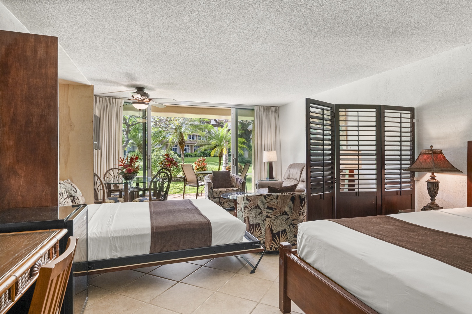 Step into your spacious retreat with two comfortable beds, tropical garden views, and your own patio seating where you can unwind surrounded by lush greenery and palm trees.
