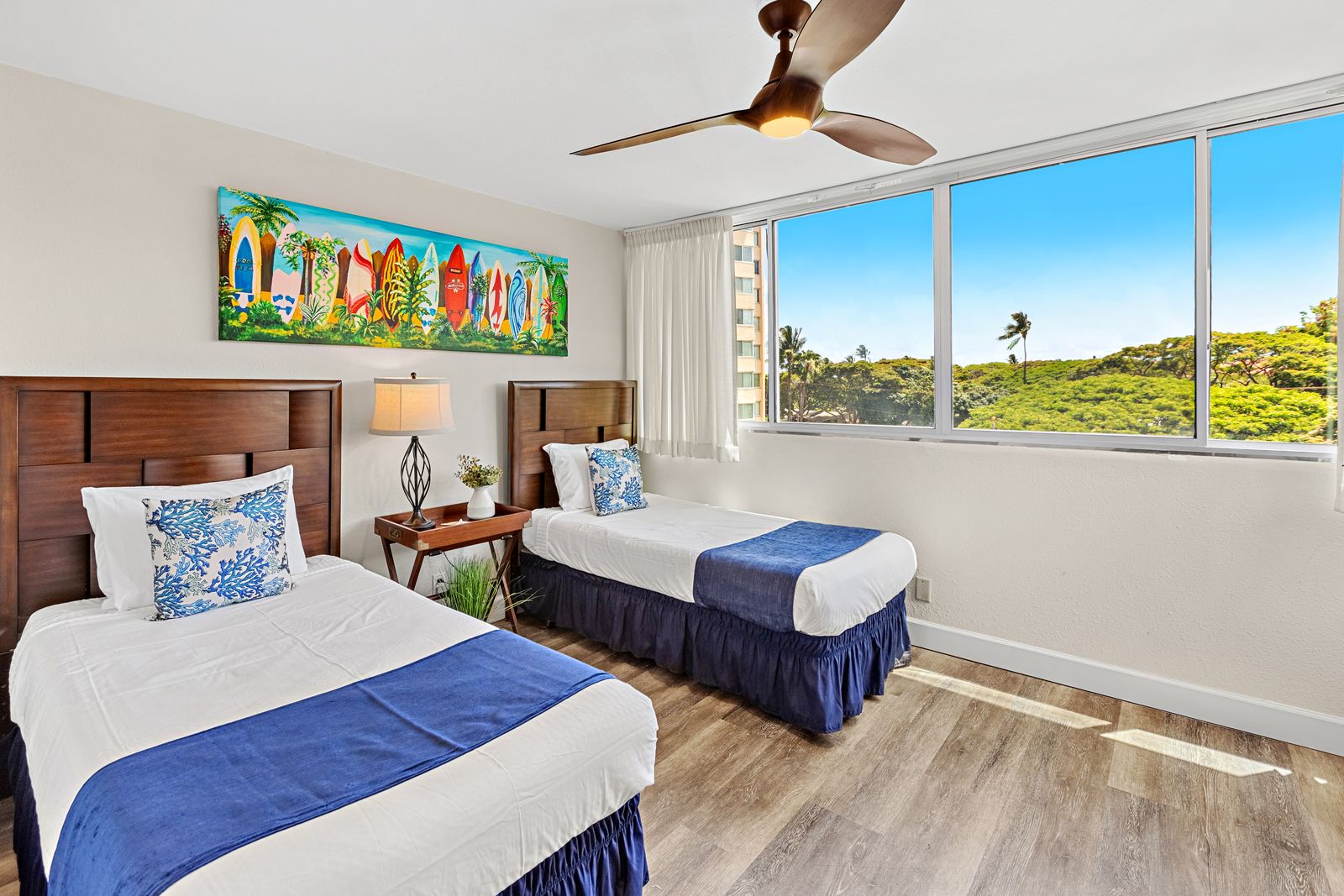 Wake up in your twin bed sanctuary with tropical surf art and stunning natural views. The ceiling fan keeps you cool while lush greenery fills your window.