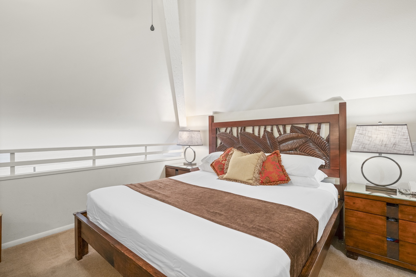 Drift off in a beautifully appointed bedroom with vaulted ceilings, elegant lighting, and a plush bed dressed with quality linens for your comfort.